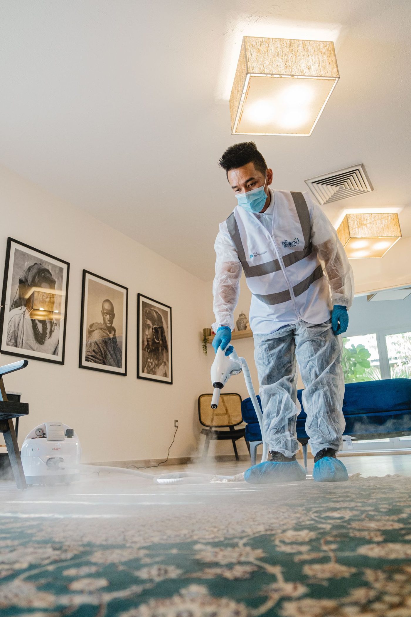 Technician extracting water from carpet with professional equipment